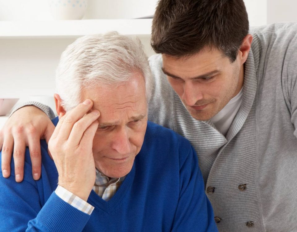 Elderly man being comforted by younger man