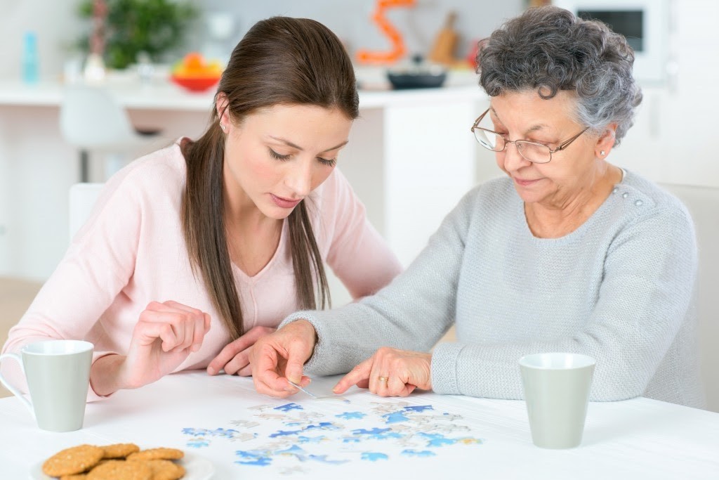 old lady and girl reading, reading old daly with care giver, alzhmeimer's progression