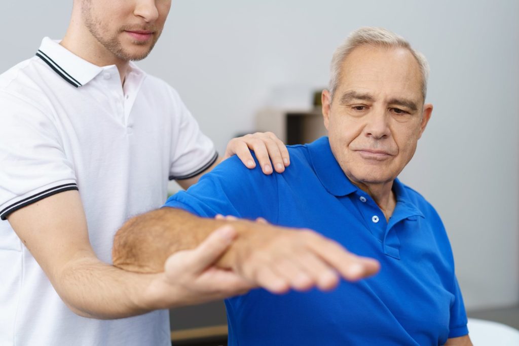 doctor helping a patient of Parkinson's to maintain their balance with exercise