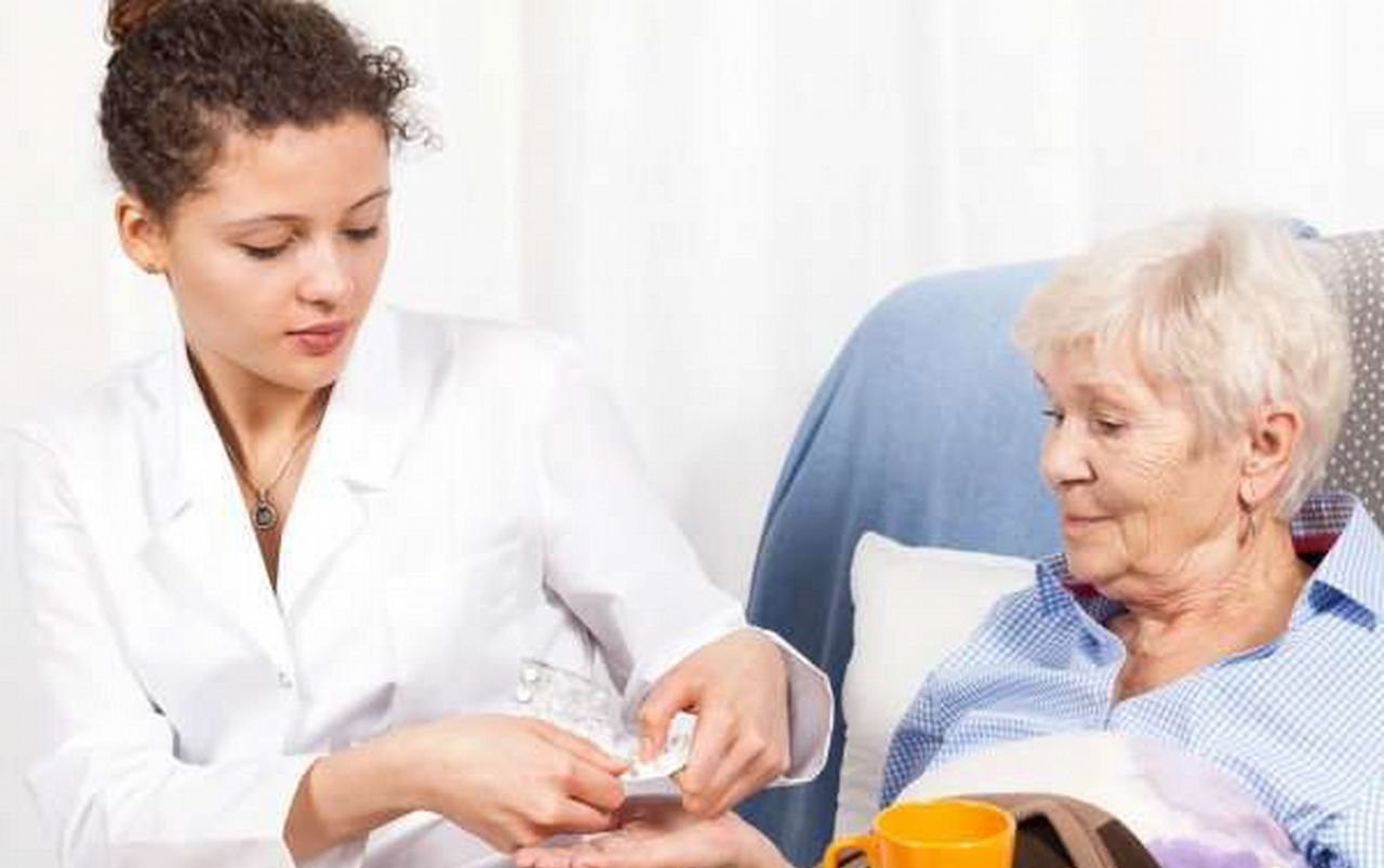 live in caregiver assisting a client in taking her medicine