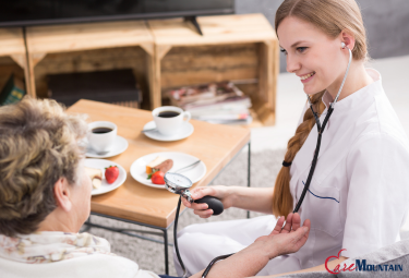 Female caregiver monitors female patients' blood pressure